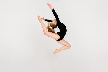 Foto op Plexiglas young beautiful girl gymnast on a white background. a young girl is engaged in gymnastics on a white background. © КРИСТИНА Игумнова