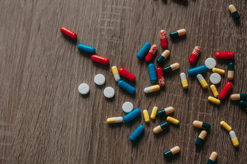 pile of pills on a wooden table