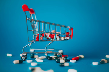 Red basket with a bunch of pills on a blue background