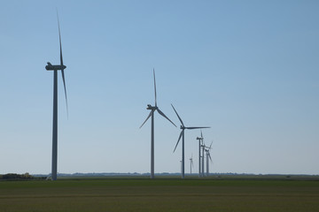 Fototapeta na wymiar Windmill for electric power production, France. Blue sky