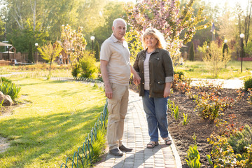 Fototapeta premium Mature couple in summer park, senior couple relax in spring summer time. Healthcare lifestyle elderly retirement love couple together valentines day concept