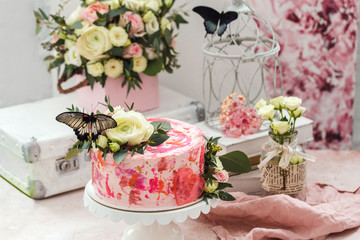 Pink cake decorated with flowers and real butterflies rose romantic atmosphere