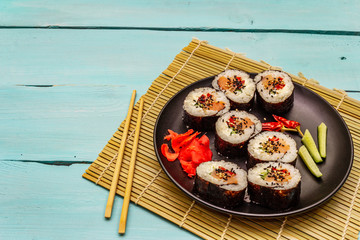 Korean roll Gimbap(kimbob). Steamed white rice (bap) and various other ingredients. Trendy turquoise background