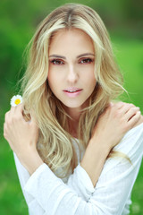Beautiful woman with a flower. Girl with camomiles. Beautiful woman portrait.