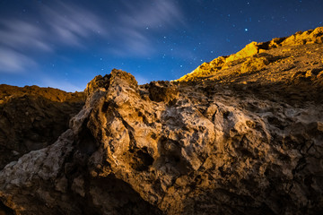 Textured dead coral rock with starry sky at background