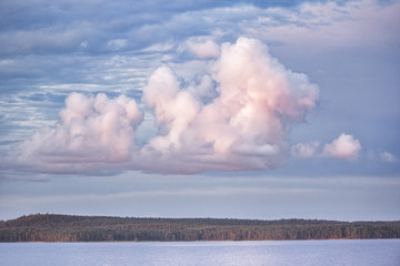 Naklejka na ściany i meble Pink clouds in the rays of the setting sun over Lake Onega. Republic of Karelia