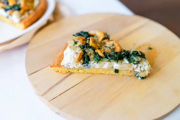 Pumpkin pie with chanterelles. A carved pumpkin in the background. Traditional Halloween dish served on a table with a white tablecloth on a wooden cutting board.