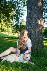 young attractive blond woman playing with her dog in green park at summer, lifestyle people concept