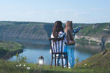 Fototapeta premium Mom and baby. A woman is sitting on a chair. Outdoors. Family and care