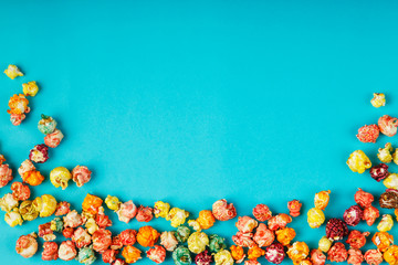 Scattered colored crispy corn on a blue background. save up space.