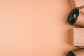 Eco-cups and food boxes are framed on a beige background. 