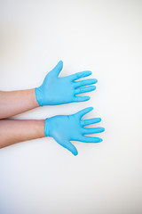 Hands in blue medical disposable gloves show a hand washing pattern