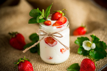 sweet homemade yogurt with ripe fresh strawberries in a jar