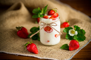 sweet homemade yogurt with ripe fresh strawberries in a jar