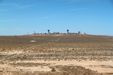 There is a base in the desert. A military or space base far from the city. Desert terrain. The base...