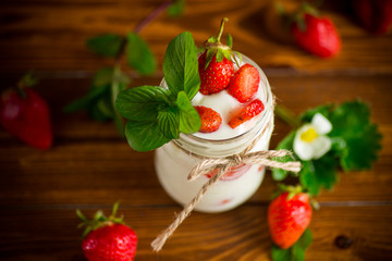 sweet homemade yogurt with ripe fresh strawberries in a jar