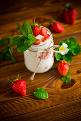 sweet homemade yogurt with ripe fresh strawberries in a jar