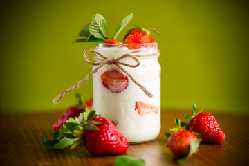 sweet homemade yogurt with ripe fresh strawberries in a jar