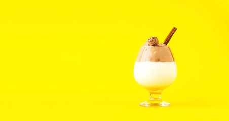 Creative layout with Dalgona Coffee on yellow background. Trendy cold Korean and Indian drink. Sustainable Wellness. Close-up