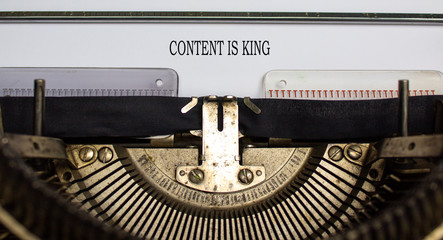 Text 'content is king' typed on retro typewriter. Business concept.