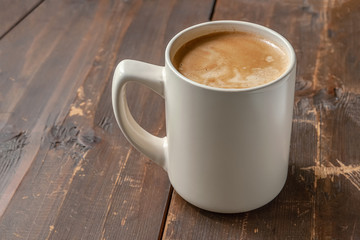 a mug of freshly brewed aromatic coffee on a wooden table