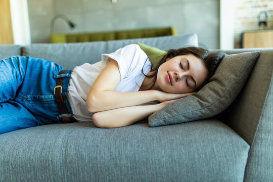Young attractive girl sleeping on the couch in the living room