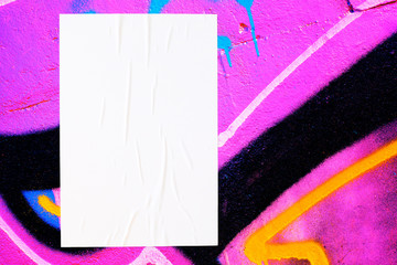 Closeup of colorful messy painted urban wall texture with wrinkled glued poster template . Modern mockup for design presentation. Creative urban city background. 