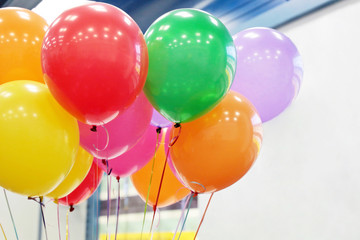 Helium balloons with ribbons in the office. Colorful festive background for birthday celebration,...
