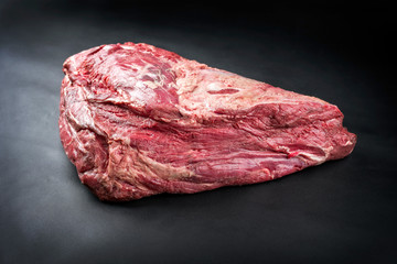 Fototapeta premium Rohe dry aged Wagyu Dickes Bugstück vom Rind als closeup auf einem schwarzen Hintergrund mit Textfreiraum