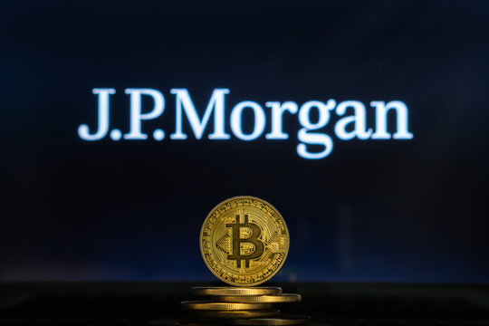 Bitcoin on a stack of coins with JPMorgan logo on a laptop screen. Cryptocurrency and blockchain adoption getting mainstream. Slovenia - 02 24 2019