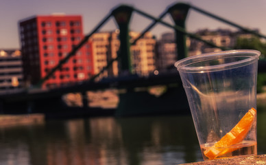 A slice of an orange in a plastic cup