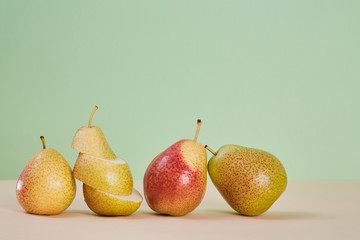 Ripe pears and slices. Mellow summer fruit. Eco-friendly food. Diet. Copy space for text. Pastel green background