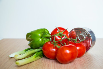 a set of delivery products, fresh vegetables and a tin can, on a wooden table