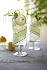 Lime, cucumber, parsley cocktail, lemonade, detox water with ice cubes in a glasses on a white plate. Detox cucumber and mint diet drink, healthy summer cooler.
