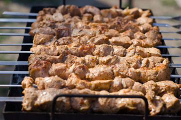 Shish kebab is grilled. Beautiful pieces of meat with a golden crust on skewers.