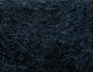 Fototapeta na wymiar Part of a beautiful abstract loft decorative black wall with ultramarine stucco scratches. Art cover stylized textural banner with space for text decoration.