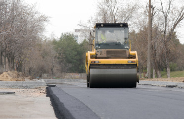 The vibratory roller levels the asphalt pavement