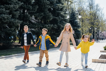 A group of children play together and walk in the Park holding hands. Friends, children