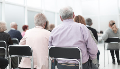 Rear view of a senior people listening a lecture