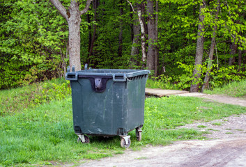 plastic container for garbage in the green forest, ecology