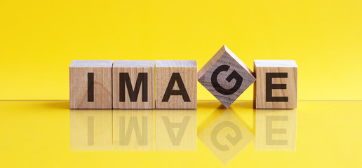 The word image is written on wooden cubes on a bright yellow background.