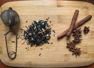tea with pieces of fruits and cinnamon on wooden desk