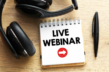 LIVE WEBINAR words written in a notebook on a wooden table.