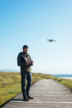 Young man flying a dron near to the beach