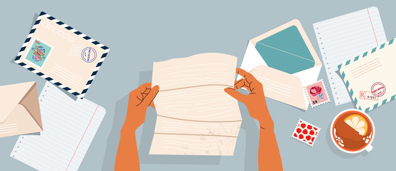 Hands holding a letter. Envelopes, post stamps and postcards on the table. Top-down view.  Modern vector illustrated banner, card design. Correspondence and postal delivery concept.