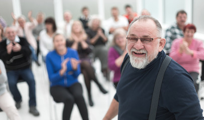 Smiling man gives a speech in meeting