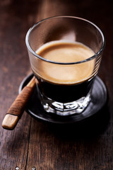  Coffee in glass cup on rustic wooden background. Close up.
