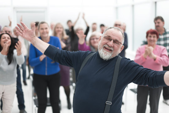 Smiling man gives a speech in meeting