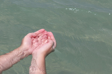 Female hands with folded palms in clear water. Concept of World oceans day