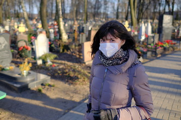 Woman in medical mask in a cemetery